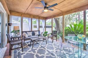 eine abgeschirmte Veranda mit einem Sofa, Stühlen und einem Tisch in der Unterkunft The River Cottage Charming Retreat with Dock in Midway