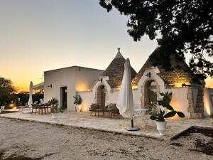 a building with a table and an umbrella at EnjoyTrulli - Countryside in Noci