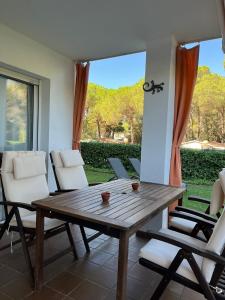 een houten tafel en stoelen op een patio bij Pals Playa Golf in Pals