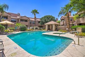 a swimming pool in a villa with palm trees at Updated Scottsdale Condo Less Than 3 Mi to Old Town! in Scottsdale