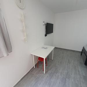 a white table with a red chair in a room at Budget Apartment LeLo Center 4 in Osijek