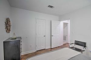 a bedroom with white walls and a bed and a chair at Updated Jackson Home about 3 Mi to JSU Stadium! in Jackson
