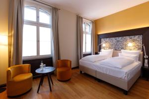 a bedroom with a bed and a table and two chairs at Hotel Alte Post in Konstanz +30 photos