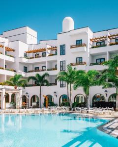 um hotel com piscina em frente a um edifício em Princesa Yaiza Suite Hotel Resort em Playa Blanca