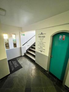 un pasillo con una puerta azul y escaleras en un edificio en Jung Palace Hotel, en Foz do Iguaçu