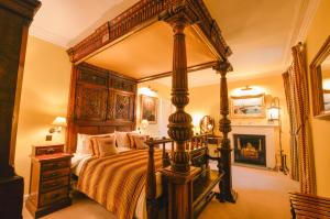 a bedroom with a large canopy bed and a fireplace at Barcaldine Castle in Oban