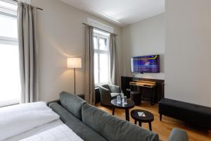 a living room with a couch and a piano at Hotel Alte Post in Konstanz