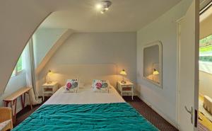 a bedroom with a bed with two tables and two lamps at Domaine De Kereven in Bénodet