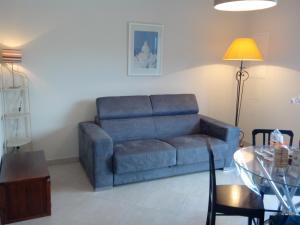 sala de estar con sofá azul y mesa en Appartement vue sur mer en Santa-Maria-di-Lota