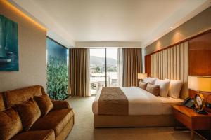 Marjan Plaza Hotel في تبليسي: غرفه فندقيه بسرير واريكه