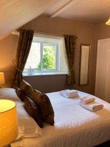 sypialnia z dużym łóżkiem i oknem w obiekcie Oakfold House w mieście Bowness-on-Windermere