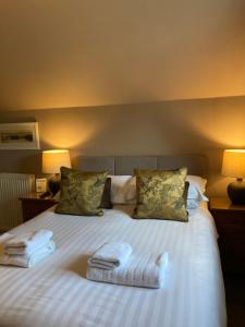a bedroom with a bed with two towels on it at Oakfold House in Bowness-on-Windermere