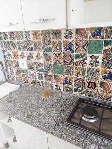 a kitchen with a counter with a tile wall at Dar Fatma in Hammamet