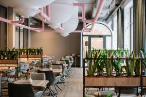 a restaurant with tables and chairs and plants at Hotel Zefir in Drohobytsch