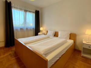 ein großes Bett in einem Zimmer mit einem großen Fenster in der Unterkunft Villa Verona in Krakau