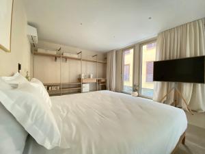 een slaapkamer met een groot wit bed en een flatscreen-tv bij Olive studios in Zadar