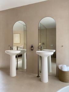 twee wastafels in een badkamer met twee spiegels bij Olive studios in Zadar