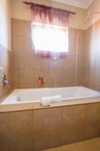 uma banheira na casa de banho com uma janela em Ramasibi Guest Services em Panorama
