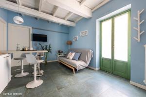 a living room with blue walls and a green door at San Francesco Guest House in Savigliano