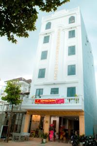 a tall white building with a sign on it at Trường Phúc Vinh Hotel in Phan Thiet