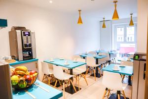 une salle à manger avec des tables et des chaises bleues dans l'établissement HOTEL AMBASSADEUR, à Lille