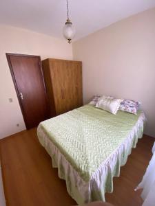 a bedroom with a bed and a wooden cabinet at Apto com garagem no centro de Nova Friburgo in Nova Friburgo