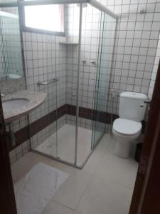 a bathroom with a shower and a toilet and a sink at Pousada Ceu e Mar in Pipa