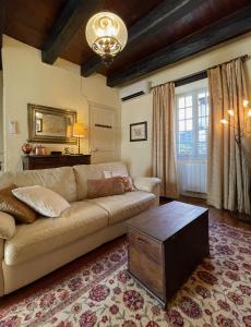 sala de estar con sofá y mesa en La Petite Maison, en Beynac-et-Cazenac