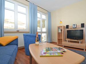ein Wohnzimmer mit einem blauen Sofa und einem Tisch in der Unterkunft Villa Seerose - Appartement 07 in Ostseebad Sellin