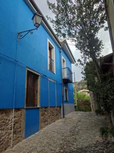 un edificio blu su una strada di ciottoli di Deiana a Santu Lussurgiu