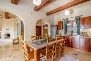 kuchnia ze stołem i krzesłami w pokoju w obiekcie The Hamlet 3 Holiday Home w mieście Għasri