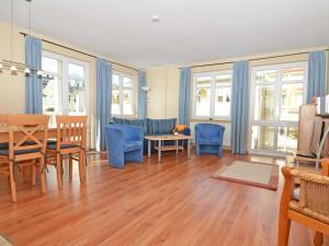 uma sala de estar com uma mesa e cadeiras azuis em Villa Seerose - Appartement 03 em Ostseebad Sellin