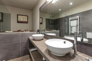 a bathroom with two sinks and a large mirror at Studio Inn De Angeli in Milan