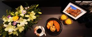 a table topped with flowers and a plate of food at Victoria by Petit Chic in Mellieħa