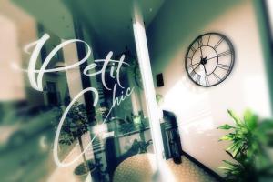 a reflection of a clock in the window of a store at Victoria by Petit Chic in Mellieħa