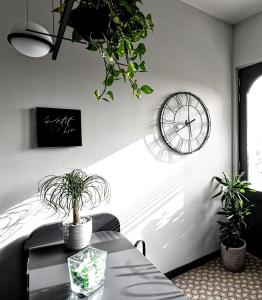 a dining room with a table and a clock on the wall at Victoria by Petit Chic in Mellieħa