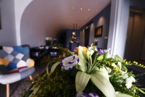 a bouquet of flowers on a table in a room at Victoria by Petit Chic in Mellieħa