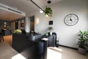 a reception desk with a clock on the wall at Victoria by Petit Chic in Mellieħa