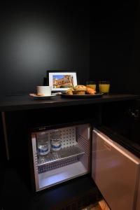 a refrigerator with water bottles and a plate of food at Victoria by Petit Chic in Mellieħa