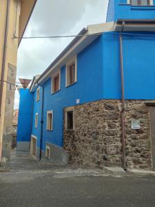 un edificio blu sul lato di una strada di Deiana a Santu Lussurgiu