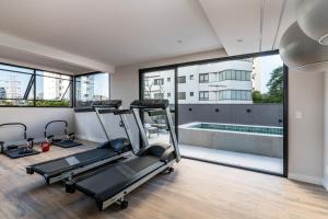 an apartment gym with two treadmills and a swimming pool at Smart Charlie Vitta Campo Belo in Sao Paulo