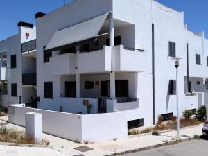 un edificio blanco con muchas ventanas en PiedraNegra, apartamento completo con patio, terraza y BBQ, en Rodalquilar