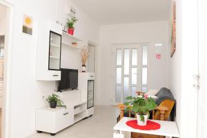 a white living room with a tv and a table at Apartman Noa 16 in Ðurđevac