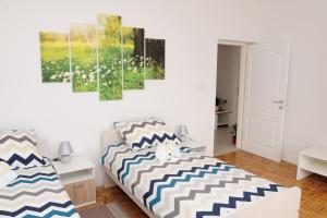 um quarto com uma cama e pinturas na parede em Apartman Noa 16 em Ðurđevac