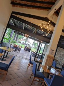 a restaurant with tables and chairs and a large window at Hotel Sand´s San Luis in San Luis Potosí