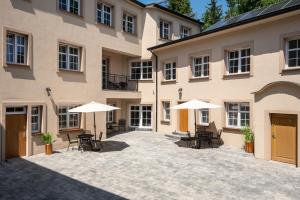 dziedziniec z krzesłami i parasolami przed budynkiem w obiekcie Central Platinum Apartments 21 w Rybniku