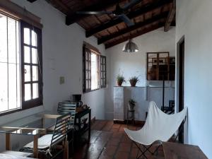 Cette chambre comprend une table, des chaises et des fenêtres. dans l'établissement Casa de las Palmeras, à Yerba Buena