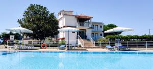 a house with a swimming pool in front of a building at Kipriotis Hotel in Arkoudi