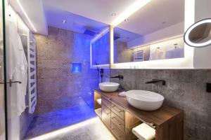 a bathroom with two sinks and a shower at Alpines Lifestyle Hotel Tannenhof in Sankt Johann im Pongau
