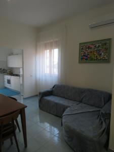 a living room with a couch and a table at Casa vacanze Aurora Tortolì in Tortolì